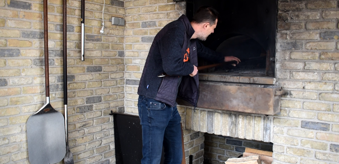 Bakkerdieineenzelfgemaaktehoutovenbrodenmaakt_Voorbereidingvandeoven_CollectieBakkerijmuseumBakkerijBaaB